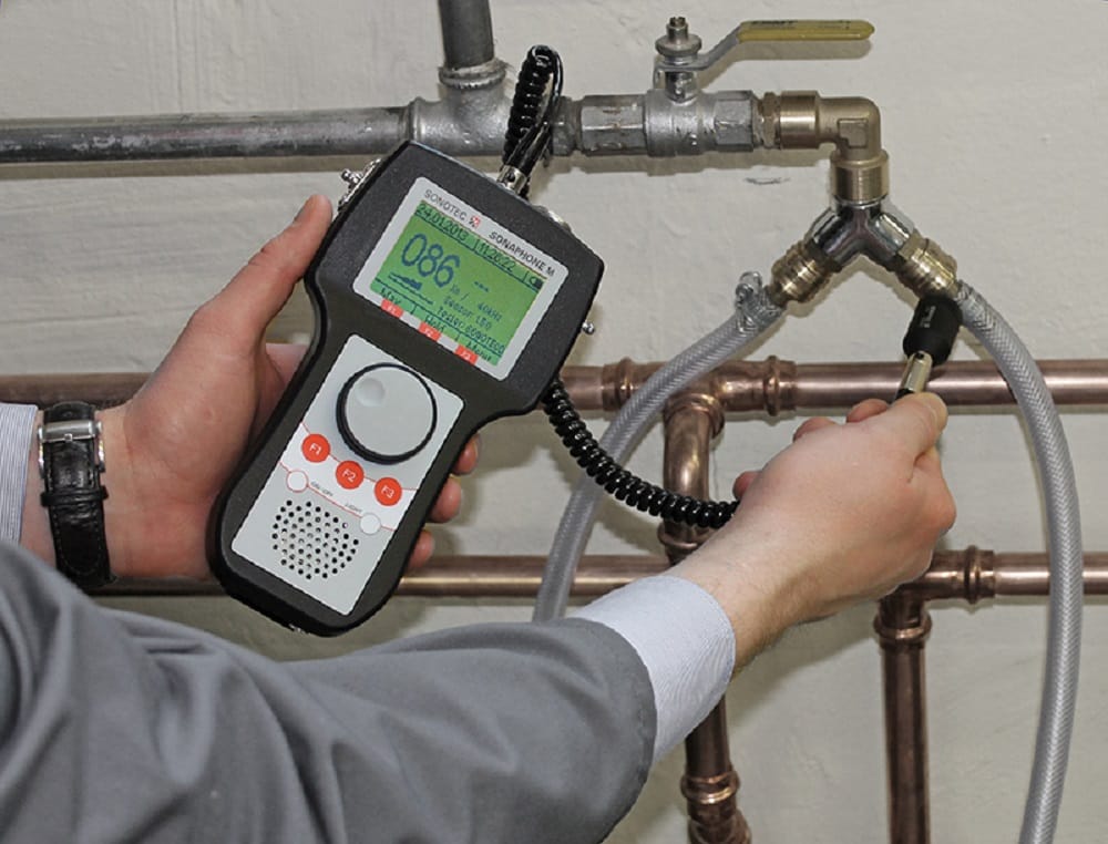 Plumber testing pipes with electronic leak detection equipment in Red Oak