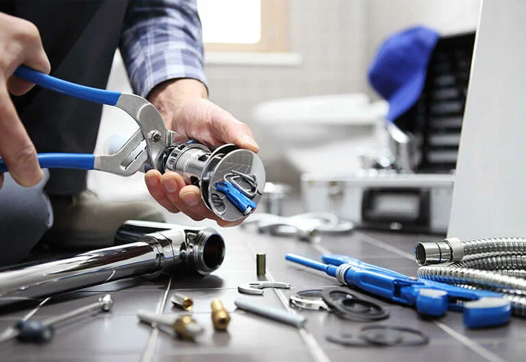 Technician repairing a plumbing fixture with professional tools in Red Oak