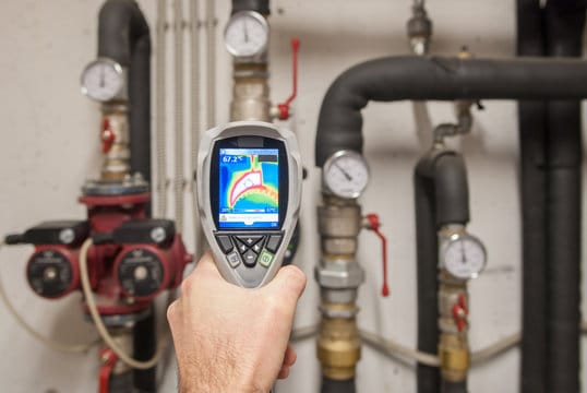 Plumber using a thermal imaging camera to inspect pipes in Red Oak