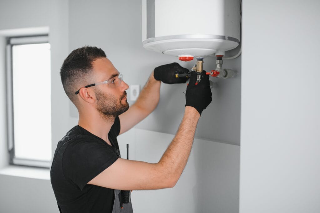 Technician performing water heater maintenance in Red Oak