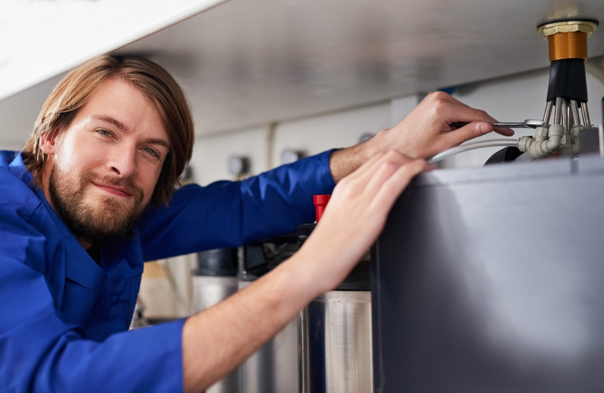 Technician servicing a residential water heater tank in Red Oak