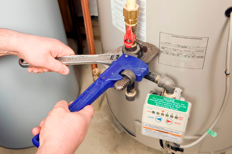 Plumber repairing a water heater valve in Red Oak